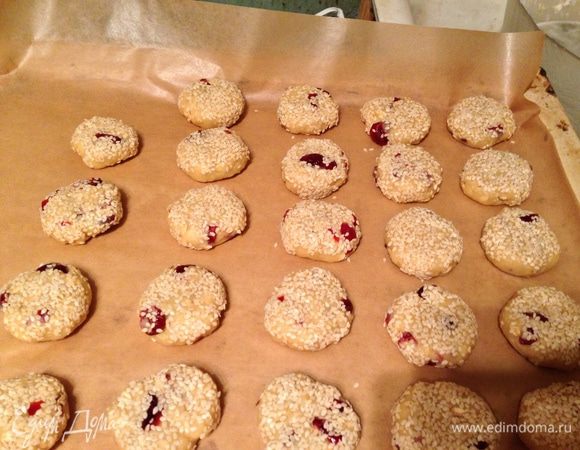 Разделить тесто на равные части, скатать в шарики и приплюснуть, обмакнуть в кунжут и положить на противень, застеленный бумагой для выпечки. Разогреть духовку до 180°C. Выпекать в течение 25-30 минут до золотистого цвета.