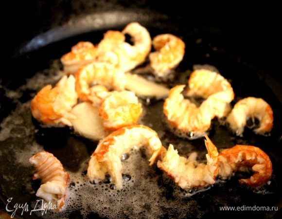 Сковороду хорошо нагреть, растопить оба вида масла и добавить очищенную и раздавленную ножом дольку чеснока. В горячее чесночное масло выложить мясо из хвостов и клешней  и прогреть в течение 1-2 минут. Убрать сковороду с огня.