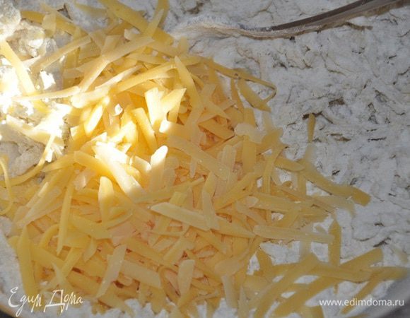 Добавить остывшую картофельно-луковую смесь в миску с мукой
Перемешать вилкой, чтобы овощная смесь равномерно соединилась с мукой.  добавить сыра (оложить немного тертого сыра) остальное добавить в миску и снова аккуратно перемешать вилкой. 
