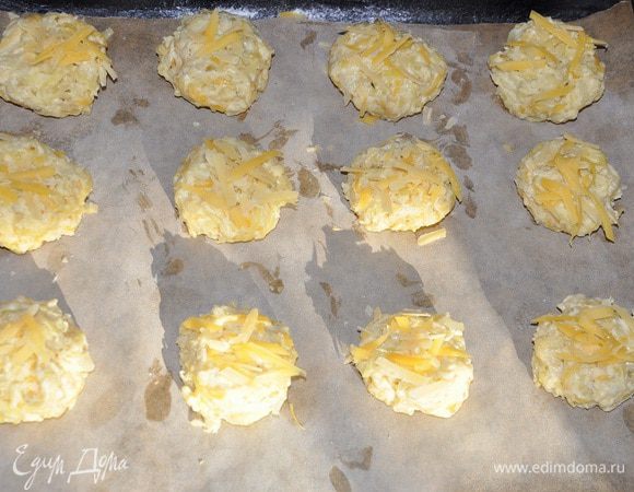 Ложкой выкладываем их на противень и придаем круглую форму, можно выложить их и руками, но для этого смочить пальцы водой. Посыпать оставшимся сыром и отправить запекаться в предварительно нагретой до 180 гр. С 25-30 минут