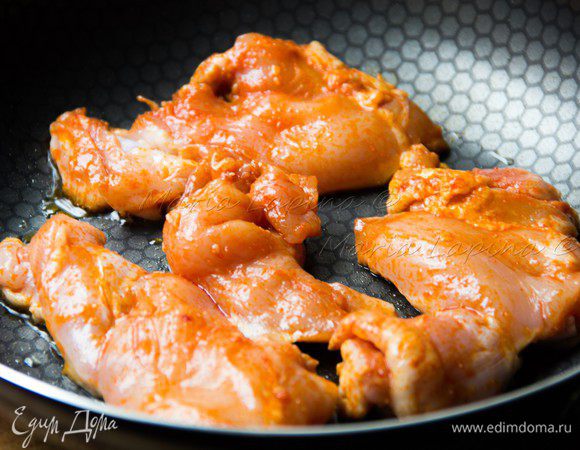 На сковороде разогреваем оливковое масло. Обжариваем курицу на сильном огне с двух сторон до золотистой корочки.  Вливаем стакан питьевой воды и не уменьшая огонь продолжаем готовить 10-15 минут пока почти вся вода не выпариться. При необходимости добавьте ещё воды. Соус который с итоге получиться будет очень насыщенным и острым. Им потом можно будет полить курицу уже в тортилье. 