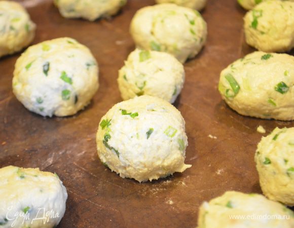 Чуть влажными руками формируем шарики с грецкий орех и выкладываем на противень, застеленный ковриком для выпечки. 