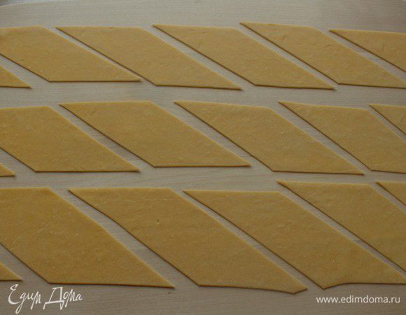 Нарезать тесто на полоски, а затем на ромбы.
