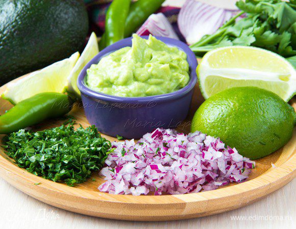 Сделаем гуакамоле. Авокадо разделить на пополам, вытащить косточку, а мякоть достать ложкой. Мякоть можно помять вилкой или воспользоваться блендером. Но главное сильно не увлекаться, т.к. соус не должен быть полностью однородным, кусочки авокадо приветствуются. Очень мелко нашинковать лук, петрушку и перец чили.