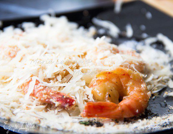 Креветки обвалять в сырной панировке и обжарить на сильном огне в большом количестве масла. Если используете готовые креветки, то хватит и 10-15 секунд на каждой стороне. Жарить лучше партиями по 3-4 штуки, чтобы успевать за ними следить. Если же креветки сырые, то увеличить время и уменьшить огонь, а можно и вовсе запечь.