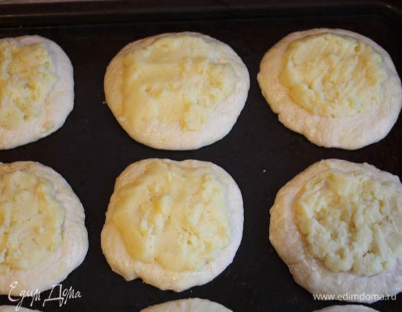 Духовку разогрейте до 180°C. Выложите лепешки на противень, смазанный растительным маслом, сделайте небольшие углубления и выложите начинку, равномерно распределяя ее почти по всей поверхности. Сверху смажьте смесью из яйца и сметаны, поставьте в духовку на 15–20 минут.