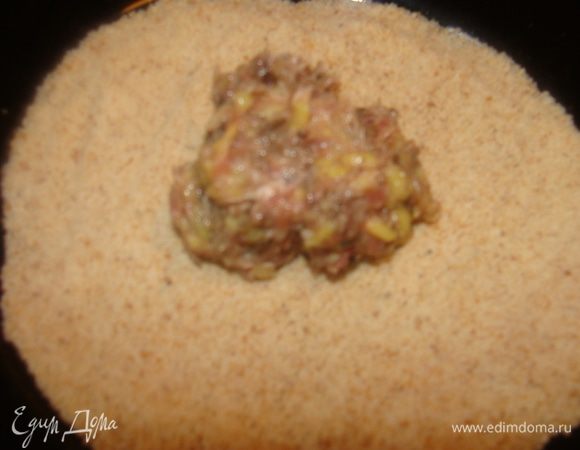 На тарелку высыпать панировочные сухари. Столовой ложкой взять кусочек фарша, обвалять в сухарях, сформировав шарик. У меня получилось 25 штук из этого количества смеси.