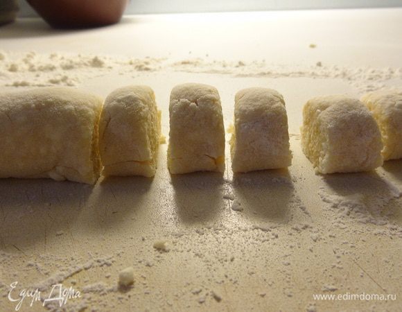 Раскатать из теста колбаску, по необходимости, подсыпая муку на рабочую поверхность. Нарезать кусочками по 1-1,5 см. Каждый кусочек обмакнуть срезом в муку и слегка прижать пальцами. Повторить с противоположной стороной, чтобы получилась шарообразная форма.
Как второй вариант придания формы - придавить чайной ложкой каждый кусочек.