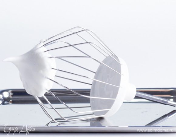 Основа торта – безе (французская меренга). Взбиваем 7 яичных белков. Когда белковая пена уже стала густой, осторожно добавляем по 2-3 чайные ложки сахара все время продолжая взбивать. В той газете рекомендовалось взбивать меренгу вращая венчиком в одну сторону и непременно вручную, стараясь поддерживать одинаковый темп. Сейчас, конечно, я пользуюсь миксером, но не нарушаю эти рекомендации, так как насадка для взбивания вращается в одну сторону, а скорость я всегда выдерживаю одинаковую (чуть выше средней), так пузырьки воздуха вбитые в меренгу будут одинакового размера, что способствует более устойчивой структуре безе. Не рекомендую уменьшать количество сахара, так как получите совершенно иной результат после запекания. Сахар забирает всю воду из яичных белков, делает взбитую массу сухой, воздушной и плотной одновременно. Взбитое безе должно быть блестящее и гладкое, должно создаваться впечатление, что оно шелковое, а при поднятии венчика должны образовываться устойчивые пики.