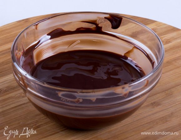 Растопить шоколад на водяной бане. Тут тоже есть свои тонкости. Конечно нужно брать шоколад лучшего качества, которое только Вы можете себе позволить, не только с материальной точки зрения, но и сточки зрения доступности широкого ассортимента.  Перегретый шоколад свернется, масло как отделиться и восстановить его структуру будет уже невозможно. Для того, чтобы этого не произошло, доведите до кипения в сотейнике воду и выключите огонь. В термоустойчивую мисочку наломайте шоколад и поставьте мисочку в воду. Действуйте аккуратно, чтоб вода не попала в шоколад. Периодически помешивайте шоколад в миске давая ему постепенно таять. Как только половина шоколада станет жидкой, вынимайте мисочку и продолжайте помешивать. Та часть шоколада, которая не успела подтаять заберет на себя излишнее тепло и шоколад будет растоплен достаточно деликатно. Растопленный шоколад должен быть жидким, гладким и блестящим.