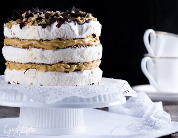 Выложить на блюдо корж, смазать кремом сверху второй, затем опять крем, третий корж. Сверху торт смазать кремом, присыпать орехами и кусочками шоколада. 
До подачи торт хранить в холодильнике. 



