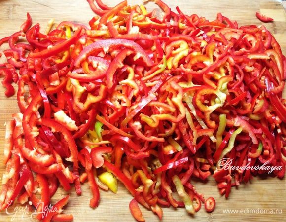 Перцы вымыть, обсушить, разрезать на 2 части и удалить сердцевину. Затем нашинковать.