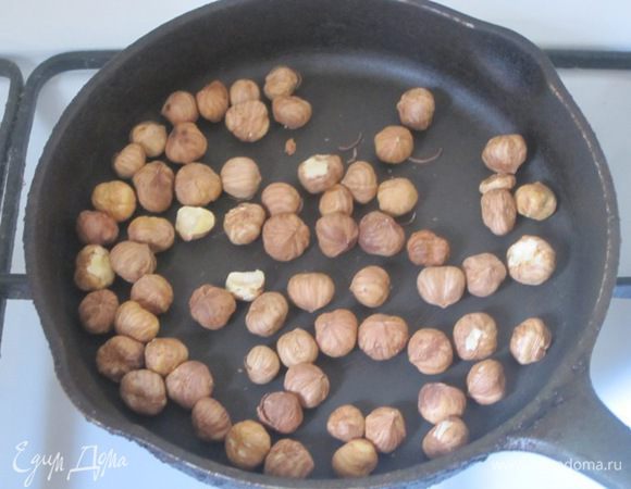 Фундук выложить на сухую сковороду. Нагревать на слабом огне, подсушивая. Снять кожуру у орехов, перетирая пальцами. Очистить все орехи от шелухи.