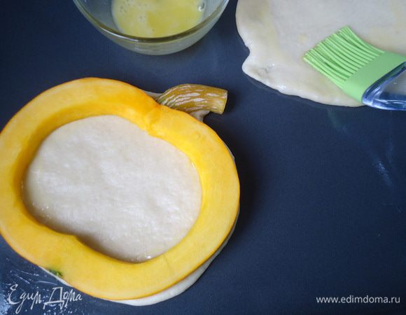 Противень смазать маслом. Уложить на него пласты теста. Смазать края теста желтком.
Положить сверху тыквенное кольцо. 
