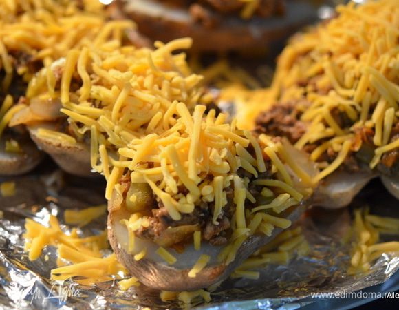 Выложить на каждый картофель готовую смесь с фаршем. Сверху сыр и поставить в духовку на 3-5 мин.