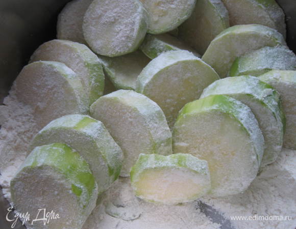 Приготовить муку, перемешанную с солью. Кабачки обвалять в муке.