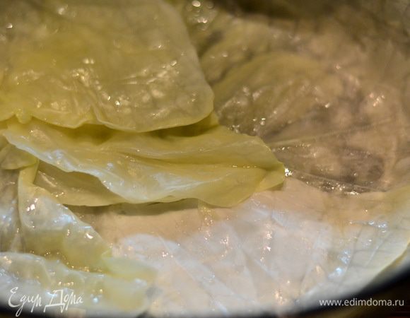 Выложить плотно друг к другу листья капусты на дно глубокой формы.