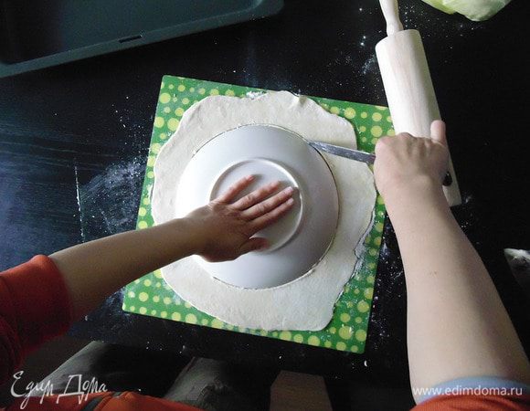 Положить, на раскатанную лепешку, тарелку и вырезать ровный круг.