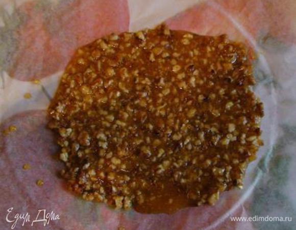 Карамелизировать сахар (просто растворить его в кастрюльке или сковороде на плите на умеренном огне, полностью дать растаять).
Если карамель получится слишком светлая - поварите ее до янтарного цвета.
Готовую карамель снять с плиты, быстро подмешать орехи и вылить массу на пергамент.