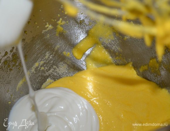 Духовку включить на 180 С. Отделить желтки от белков. Взбить желтки с двумя стаканчиками сахара. 
Продолжая взбивать, добавить в желтки йогурт и следом растительное масло. Затем добавить тертую цедру половинки лимона.
