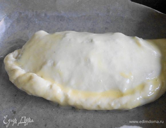 Накрыть второй частью и защипать края. Смазать взбитым желтком. Выложить на противень и поставить в разогретую до 180 градусов духовку  на 15 минут или до получения золотистой корочки.