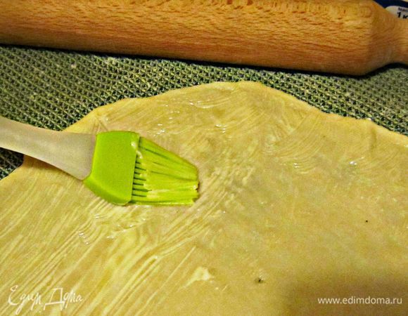 Тесто разделить на две части, т.к. из данного количества получается 2 штруделя. Каждую часть раскатать как можно тоньше (в идеале - толщиной, как лист бумаги ). Лучше всего раскатывать тесто, слегка растягивая его от центра в разные стороны. Делать это надо очень осторожно, чтобы не порвать и не повредить тесто. В результате,должны получиться прямоугольники размером 40 на 50 см. Затем смазать поверхность теста сливочным маслом.