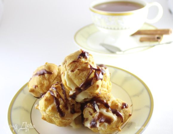 Тем временем, сделать надрезы в каждом шарике. Можно использовать кондитерский мешок.
Но я люблю крем добавлять чайной ложечкой, чтобы он немного выходил на пределы шарика:)
Приготовить глазурь. Выложить в ковш все компоненты глазури и и растопить на водяной бане. Как шоколад станет мягким, интенсивно помешать 1-2 минуты. Глазурь должна быть блестящей.
Остудить. В холодном виде глазурь станет более густой, но будет свободно стекать с ложки.
Начинить все эклеры кремом и сверху брызгами нанести всю глазурь. Поставить пирожные в холод на 1 час.
Пирожные очень вкусные:) приятного аппетита!