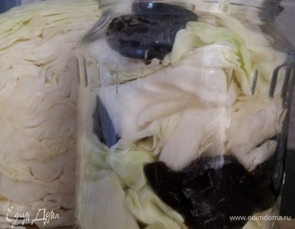 Закладываем капусту в банку, чередуем её с черноcливом и чесноком.