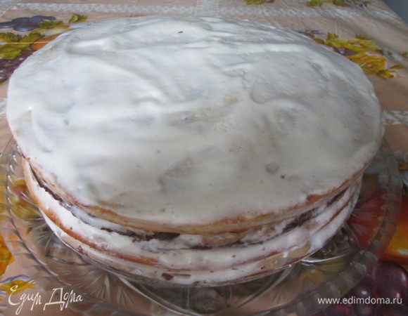 Приготовим крема. Для масляного кофейного крема яйца взбить  сахаром в пышную пену. Добавить растворённый в воде кофе, сливочное масло. Взбить в пышную массу. 
Для сметанного крема сметану взбить с сахаром и ванильным сахаром. 
Остывшие коржи сложить один на другой в такой последовательности: корж с какао, затем корж с орехами, корж с маком и корж с изюмом. Каждый корж смазать кремом, чередуя масляной кофейный и  сметанный крем. 