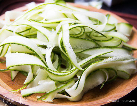 Цукини помоем и нарежем на пласты шириной примерно 2 см. Затем с помощью овощечистки нарежем его ленточками. Отвариваем пасту.