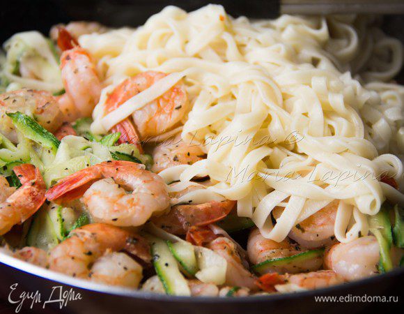 Добавляем готовую пасту и пару горстей сыра к креветкам с цукини, перемешиваем. Накрываем крышкой и даем подружиться минутку.