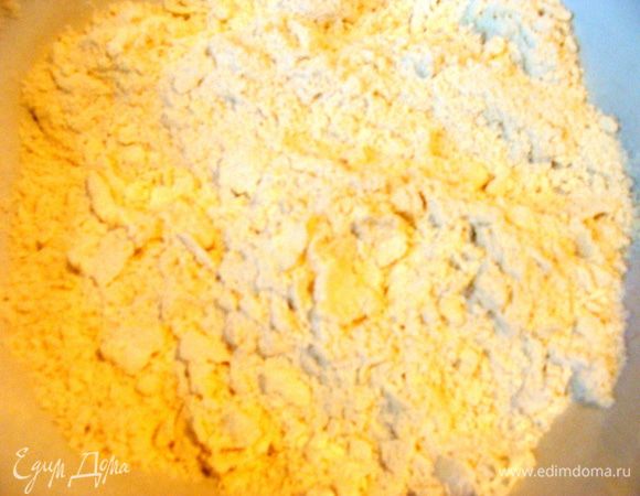Холодное масло настругать кусочками, добавить муку и разрыхлитель. Размять руками до образования крошки.