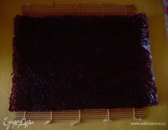 Положить лист сухой морской капусты на бамбуковый коврик (я использую бордовую нори, традиционную для роллов, но с зеленой тоже вкусно).