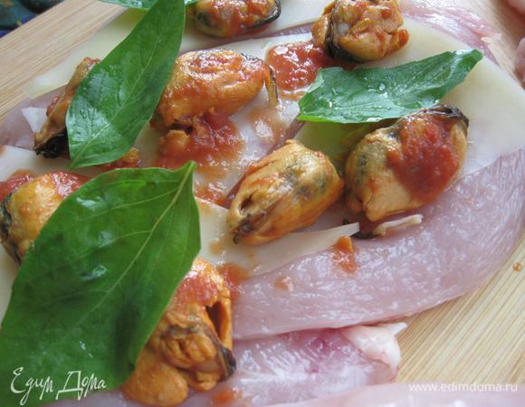 Положить  на филе кусочки сыра, листики базилика, мидии.