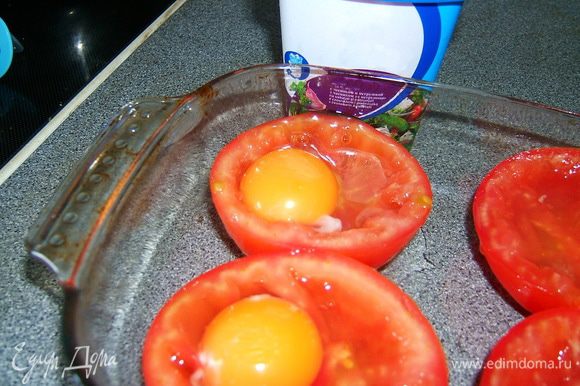 В каждую помидору разбить сырое яйцо. Положить по небольшому кусочку сливочного масла.