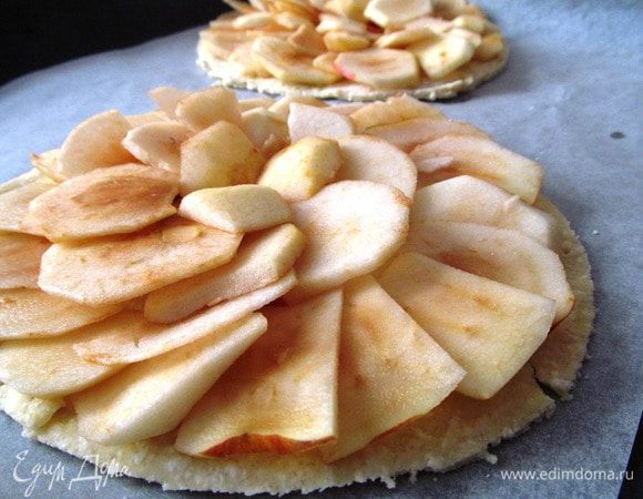 На противень, выстланный пергаментной бумагой, кладем тесто, выкладываем яблоки внахлест. 