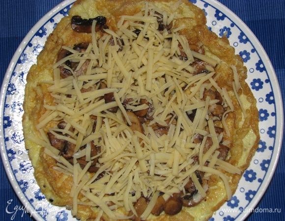 На яичный блинчик выложите грибы и сыр.