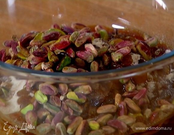 Хлопья перемешать с мукой, сахаром, изюмом, фисташками и солью, влить ванильный экстракт и кленовый сироп.