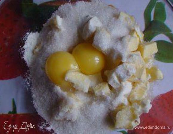 Для песочного теста всыпать в миску муку, добавить нарезанное кусочками масло, сахар, ванильный сахар и желтки.