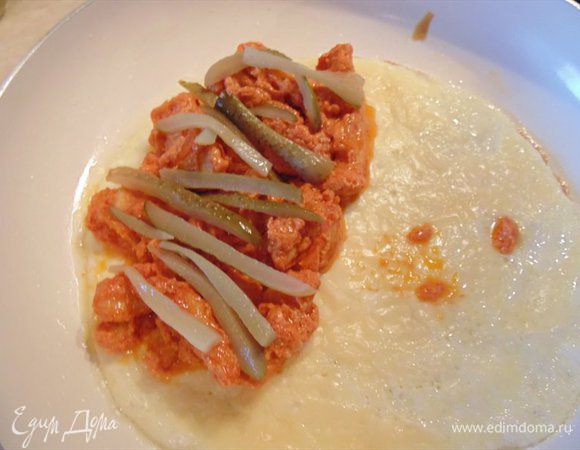 Сверху выкладываем маринованные огурчики, сворачиваем бризоль, накрывая начинку второй стороной блина и подаем на стол.