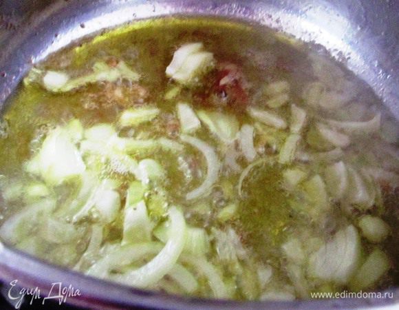 Сразу же выкладываем тонко порезанный лук и чеснок, жарим до золотистого цвета. 