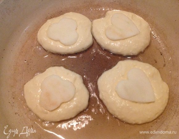 Ложкой выкладывать тесто, на каждый оладушек положить по яблочной фигурки и чуть-чуть вдавить. Так оладьи обжарить с двух сторон на хорошо разогретой сковородке.
