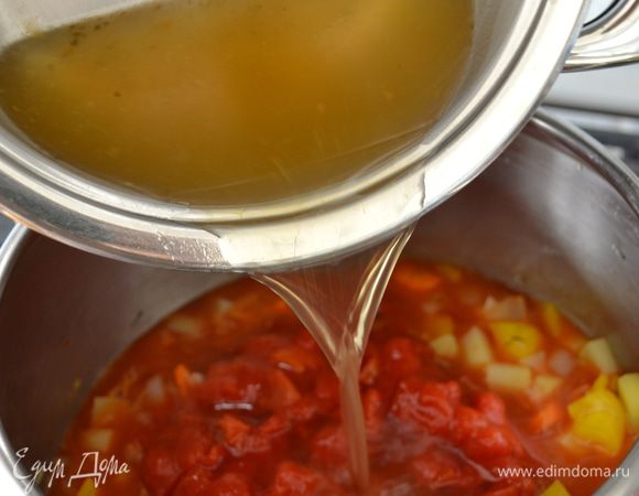 Выложить к овощам измельченные помидоры (с соком) и бульон. Накрыть крышкой и дать провариться 7-9 минут, пока овощи не станут мягче. 