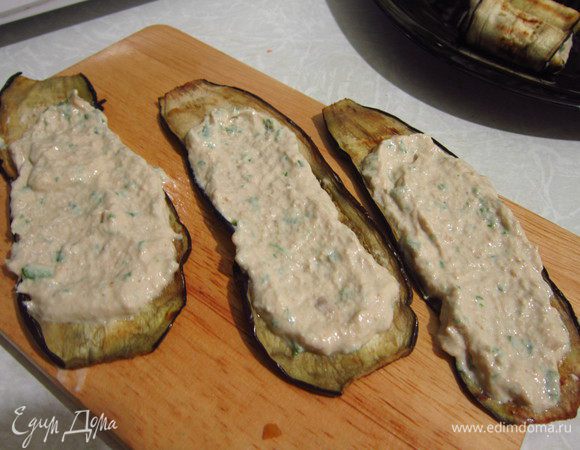 Нанести начинку на полоски баклажана и свернуть в рулеты