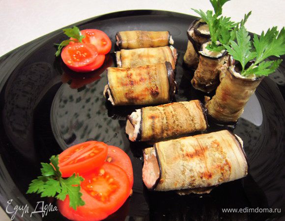 Рулеты выложить на блюдо, украсить помидорками черри и петрушкой. Приятного аппетита!