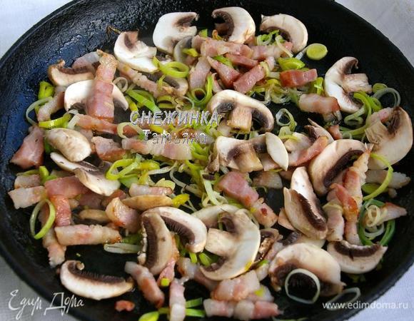 Кладём в сковороду грудинку, обжариваем, кладём лук и шампиньоны, помешивая, жарим до румяности пару минут, по необходимости можно добавить немного растительного масла.