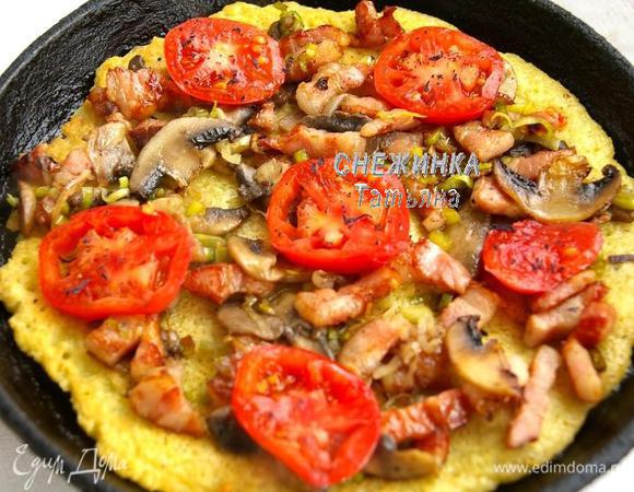 Переворачиваем картофельный блин. На него распределяем начинку. Кладём кольца помидора, посыпаем измельчённым сушёным базиликом. 