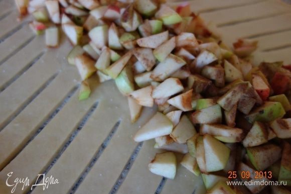 Середину теста обсыпать 40 г сахара, выложить яблоки и посыпать их корицей.