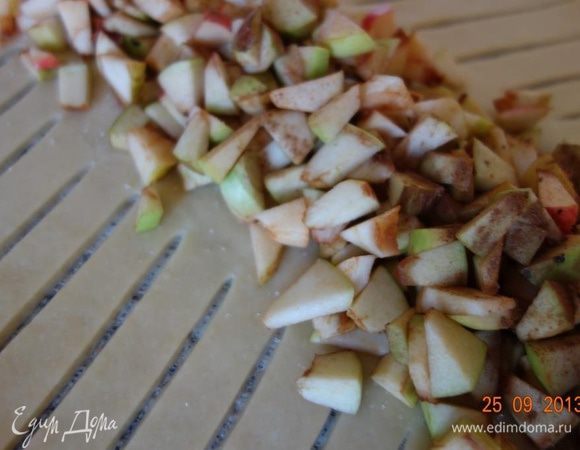 Середину теста обсыпать 40 г сахара, выложить яблоки и посыпать их корицей.