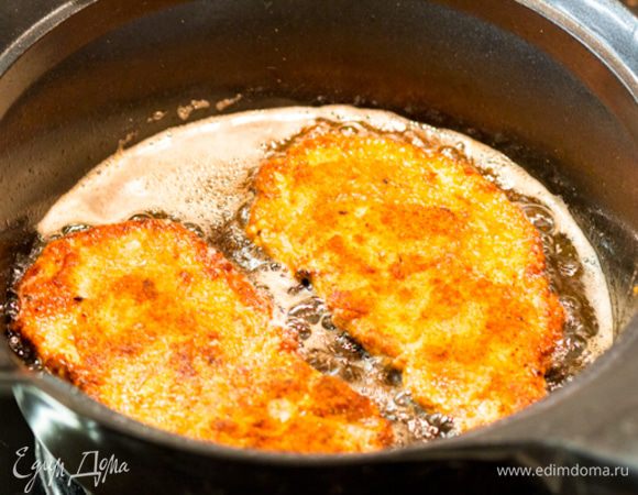 Переворачиваем на другую сторону, и так же жарим до золотистой корочки. На это уйдет всего пара минут. При этом корочка будет хрустящей, а мясо достаточно прожариться, так как оно очень тонкое. Снимаем шницели и кладем на тарелку выстеленную несколькими слоями кухонных бумажных полотенец, чтобы они впитали излишки жира.